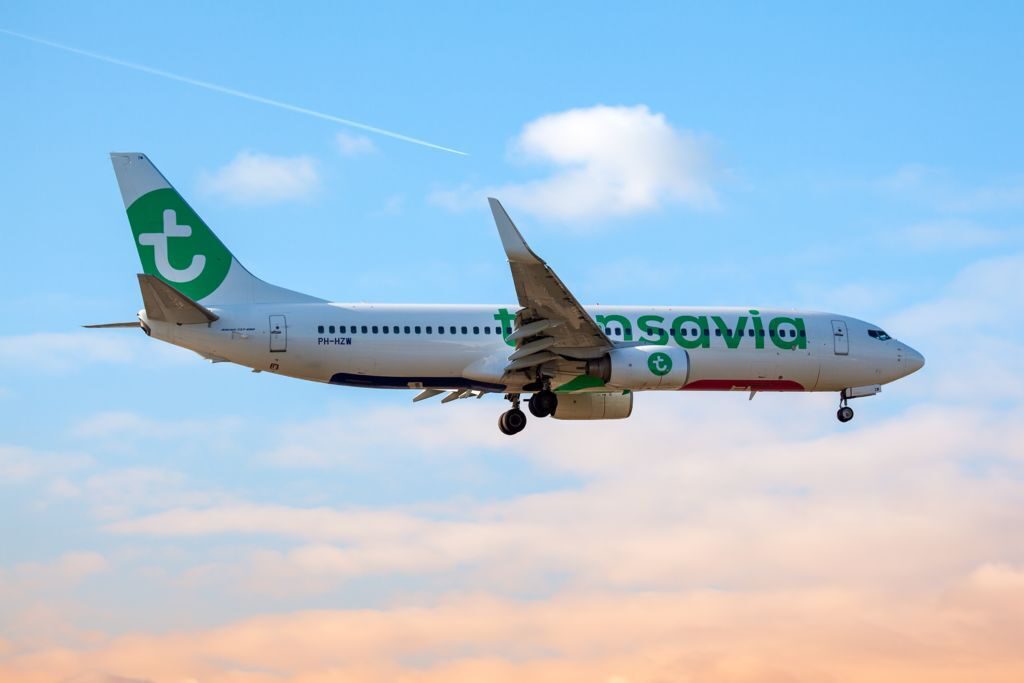 Vliegtuig van Transavia in de lucht tijdens zonsondergang