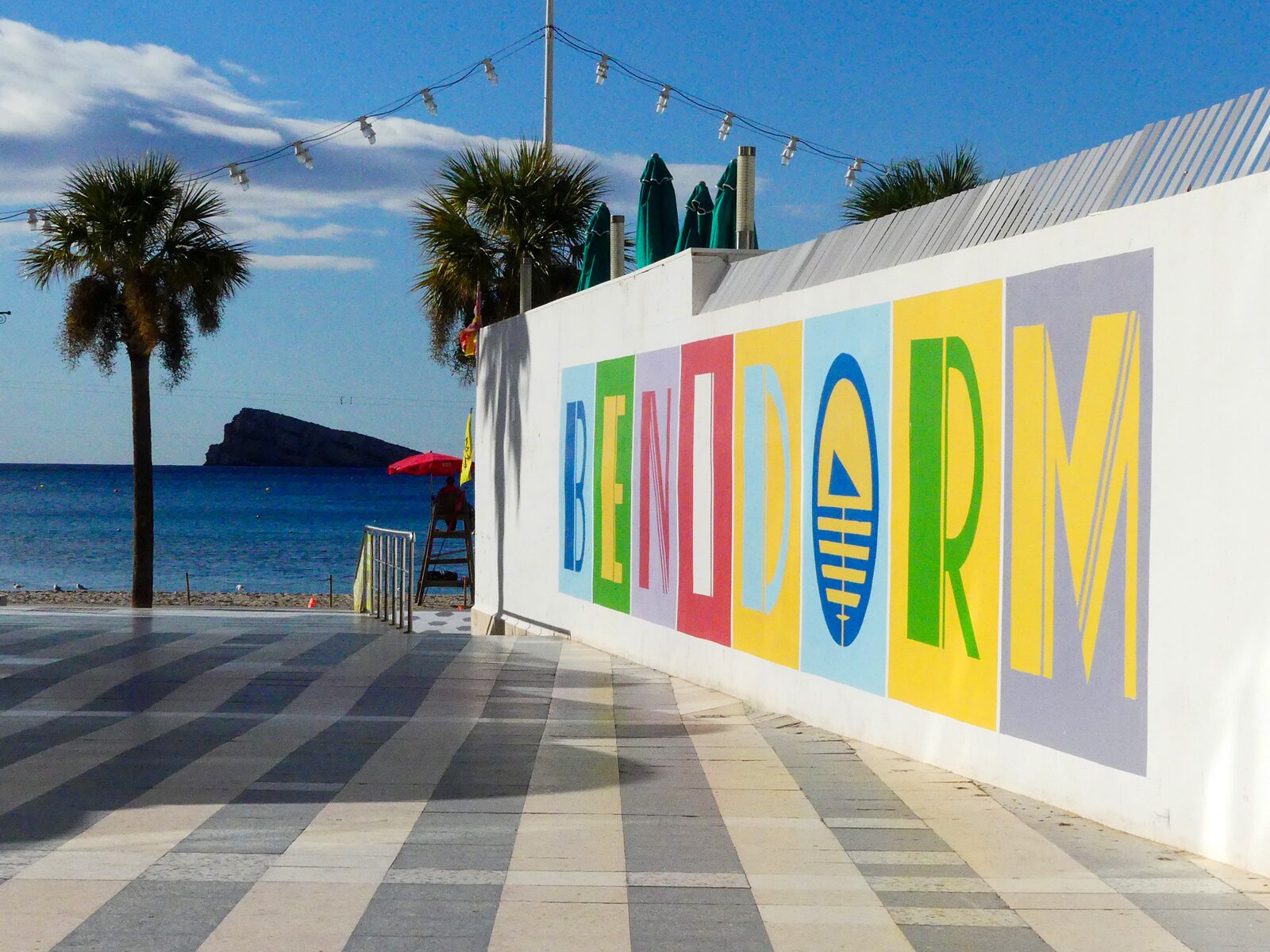 Uitzicht op Playa de Levante en de rots bij de boulevard van Benidorm met het woord Benidorm in kleurrijke letters op een muur