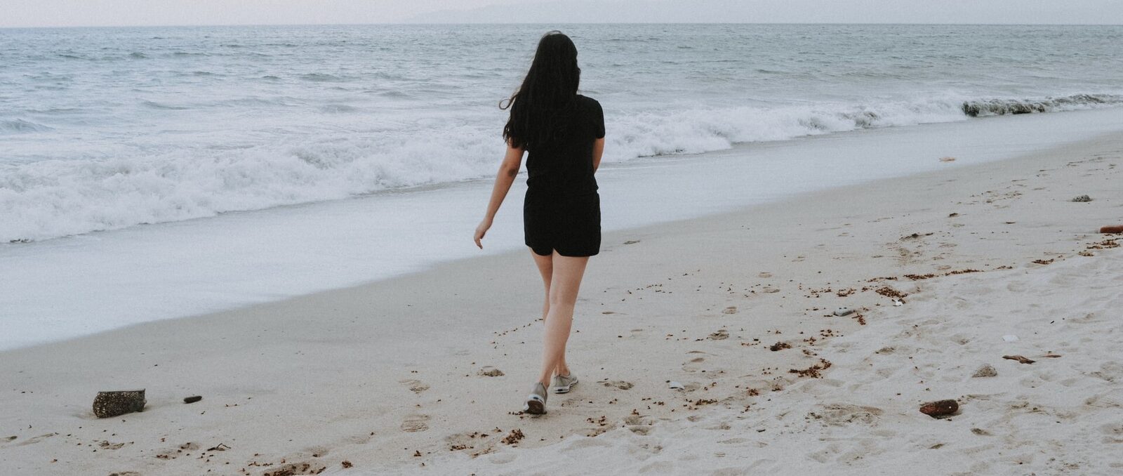 Een vrouw die op het strand wandelt