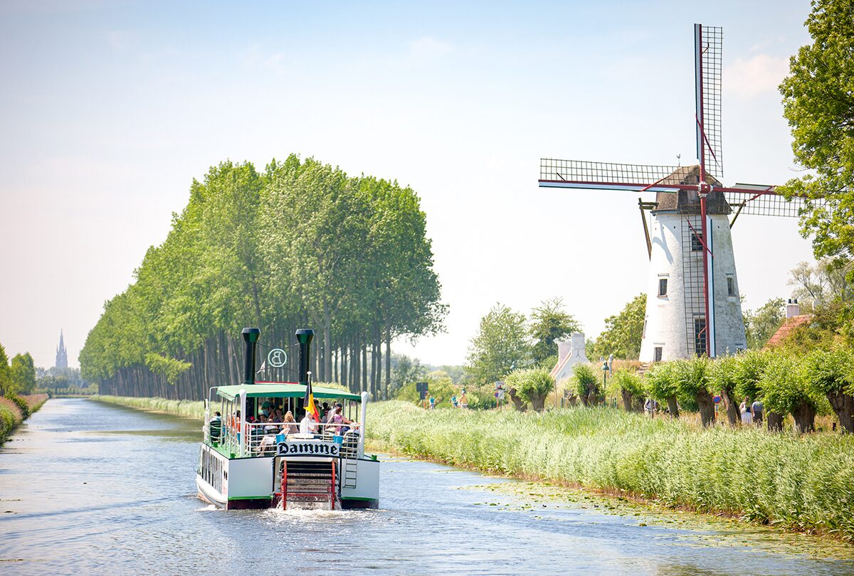 De Damse Vaart met een bootje en wandelaars en fietsers langs de vaart