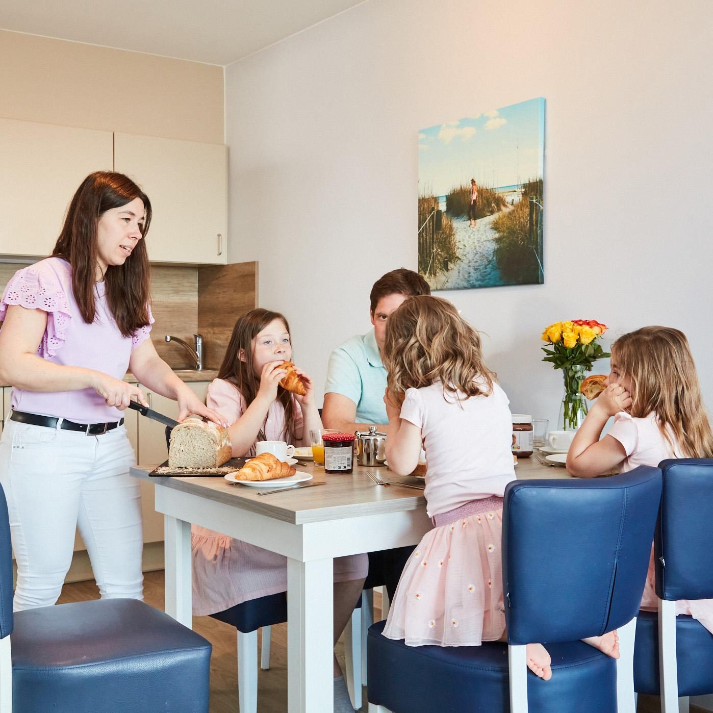 Een familie aan het ontbijten in een vakantieappartement van Holiday Suites