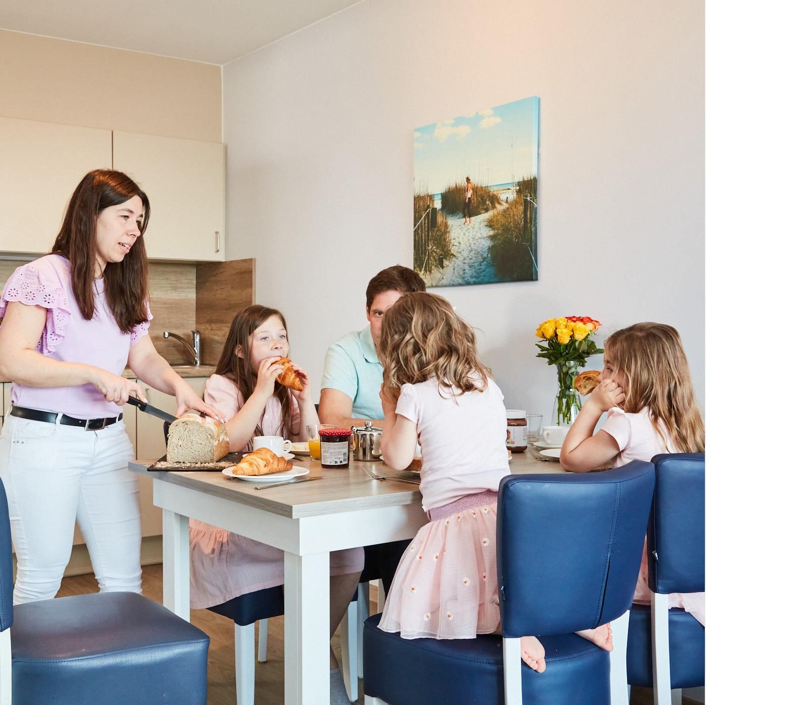 Een familie aan het ontbijten in een vakantieappartement van Holiday Suites
