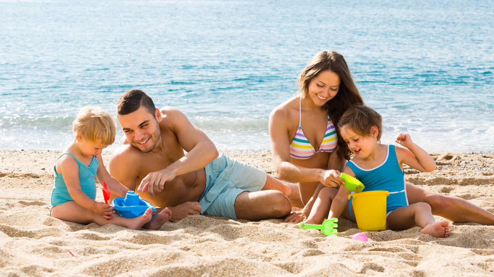 Familia con niños pequeños en la playa