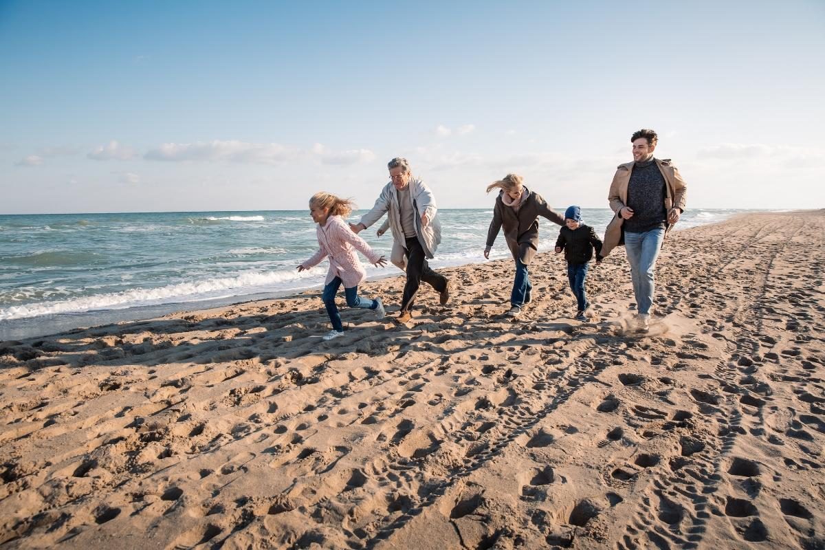 Een gezin aan het wandelen en spelen op het strand