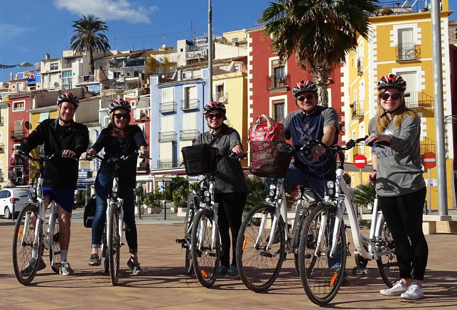 Gente en bicicleta cerca de las coloridas casas de Villajoyosa