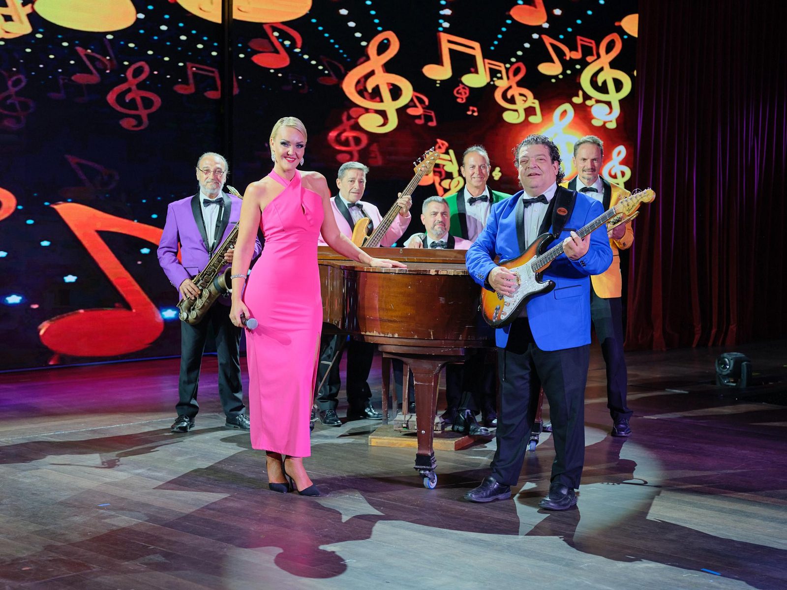 Singer on grand piano with several musicians during the AIRE show in Benidorm Palace