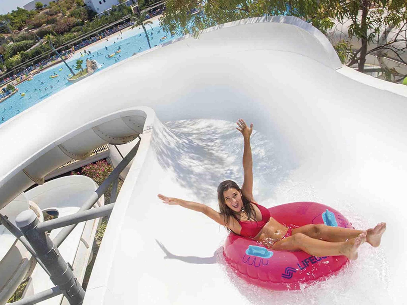Girl on pink swimming ring in the Zigzag Giant Slide in Aqua Natura