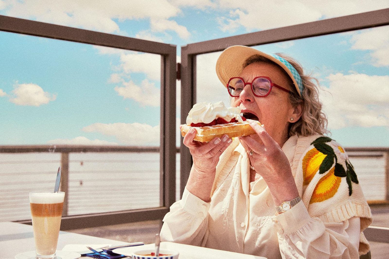 Een oudere vrouw geniet van een wafel op het terras van de Belgium Pier in Blankenberge