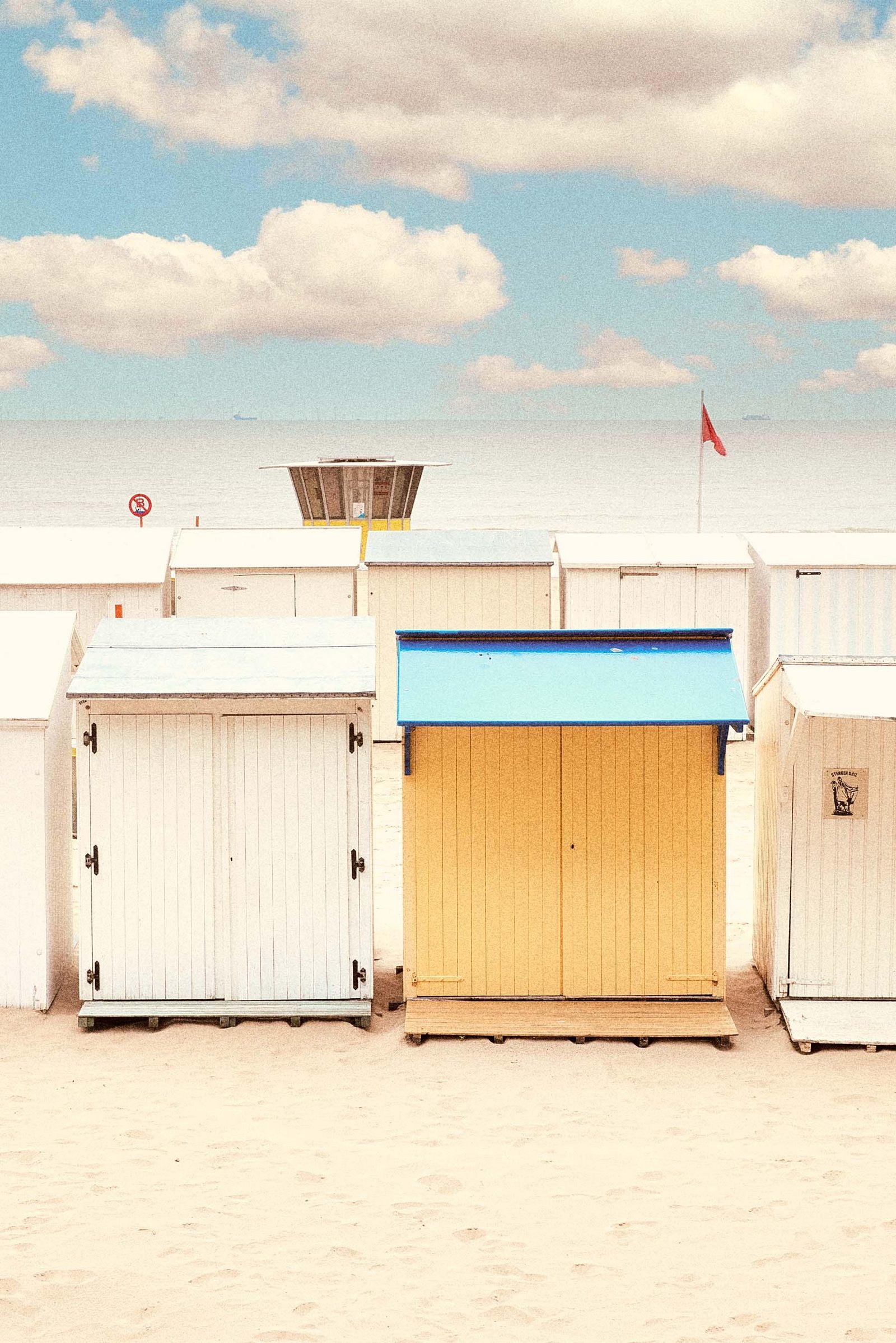 Een rij strandcabines op het strand van Blankenberge met de zee op de achtergrond