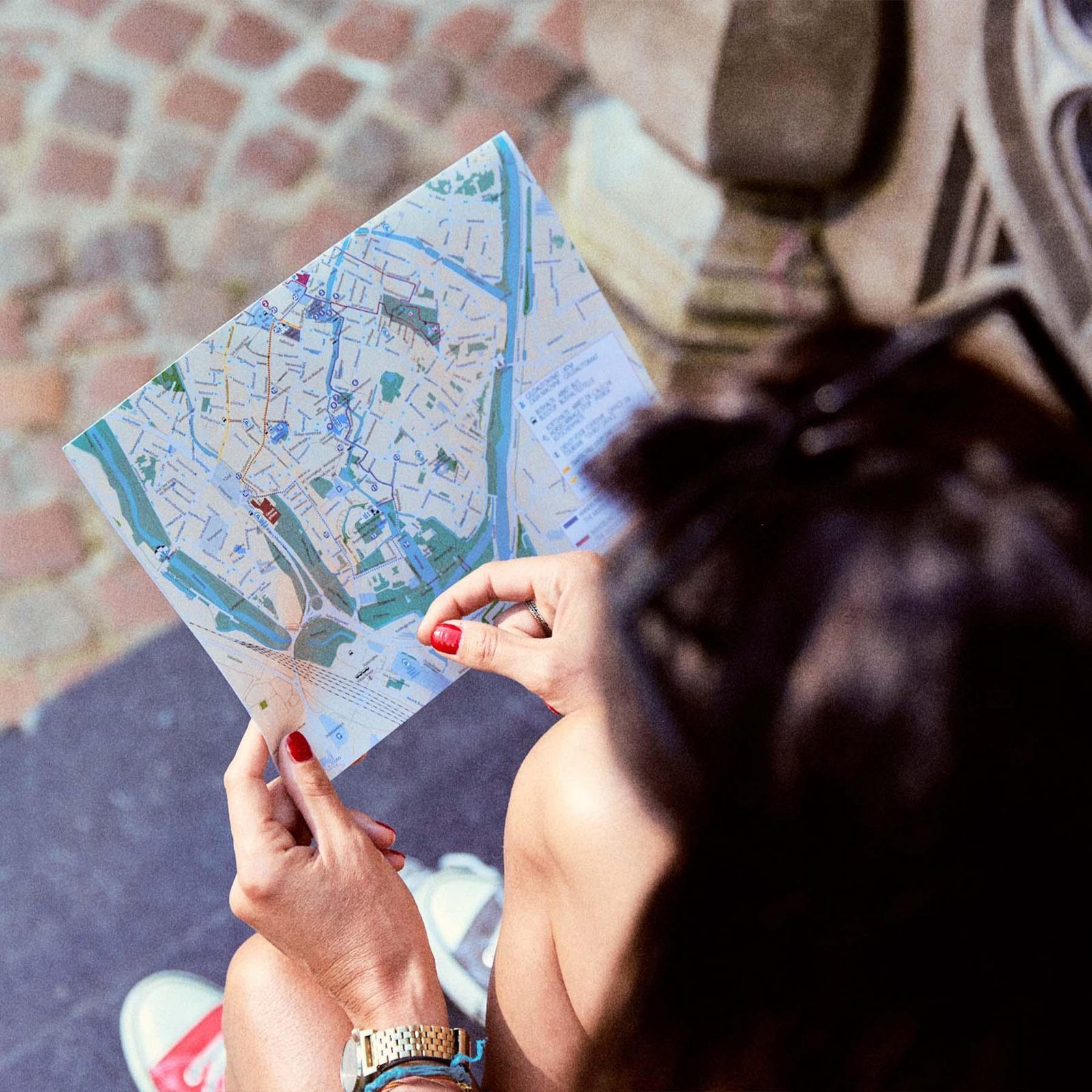 Een vrouw kijkt op een stadsplan van Brugge