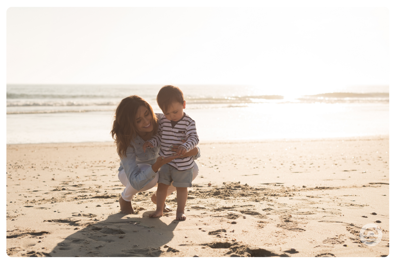 Mother with child on beach enjoying spring sunshine